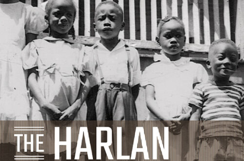 The Harlan Renaissance, black and white photo of five Black children arranged in heigh order in front of a front porch where a Black woman stands behind the railing